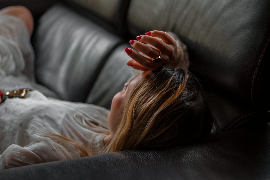 woman lying on gray couch felling stress
